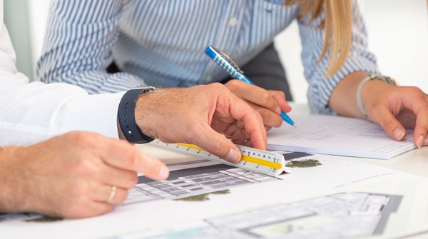 Mehrere Personen arbeiten an einer technischen Zeichnung