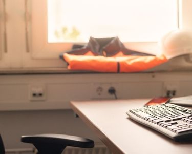 Ein leerer Arbeitsplatz mit Warnweste im Hintergrund