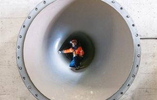 Ein Mitarbeiter prüft eine Rohrleitung