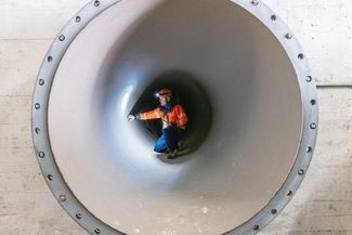 Ein Mitarbeiter prüft eine Rohrleitung