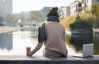 Eine Studentin sitzt am Wasser und denkt über Ihren Karriereweg nach