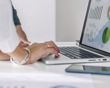 Laptop mit einer Präsentation und zwei Betrachtenden