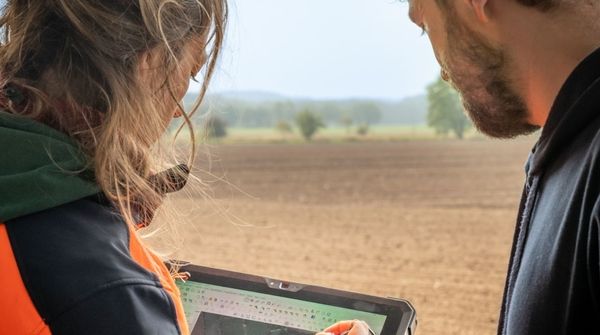 Zwei Mitarbeitende in Halle (Saale) bei einer landschaftlichen Vermessung