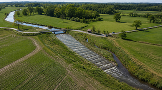 Grüne Landschaft mit Fluss und Brücke