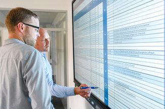 Zwei Mitarbeiter besprechen einen Projektplan