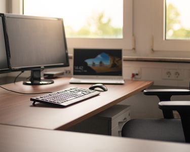 Ein leerer Arbeitsplatz mit Warnweste und Bauhelm im Vordergrund