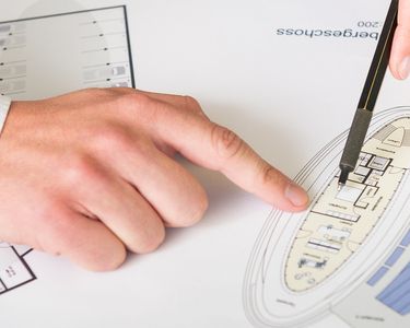 Überprüfung eines Gebäudeplans auf Papier